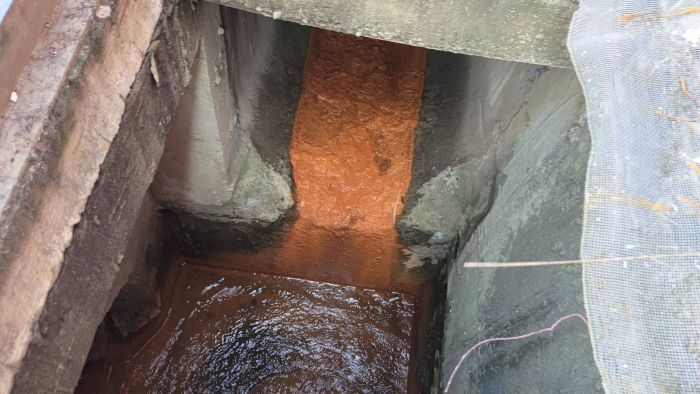 《圖說》土紅色色素沉積於水溝中。〈環保局提供〉