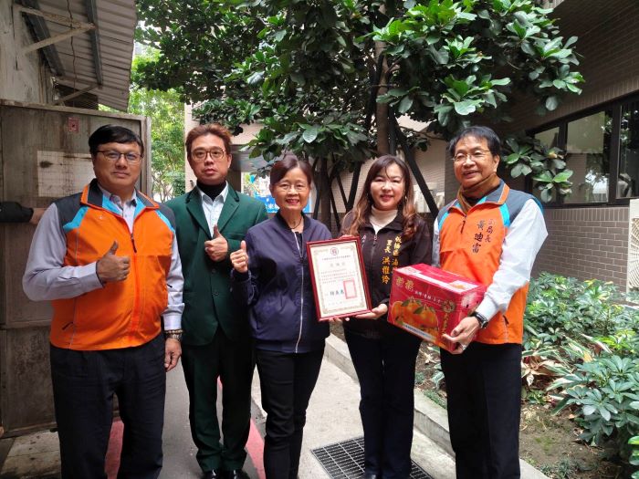 《圖說》湳興里長洪雅鈴感謝郵務同仁以實際行動守護社區弱勢致贈感謝狀,中為板郵局長胡美惠。〈板橋郵局提供〉